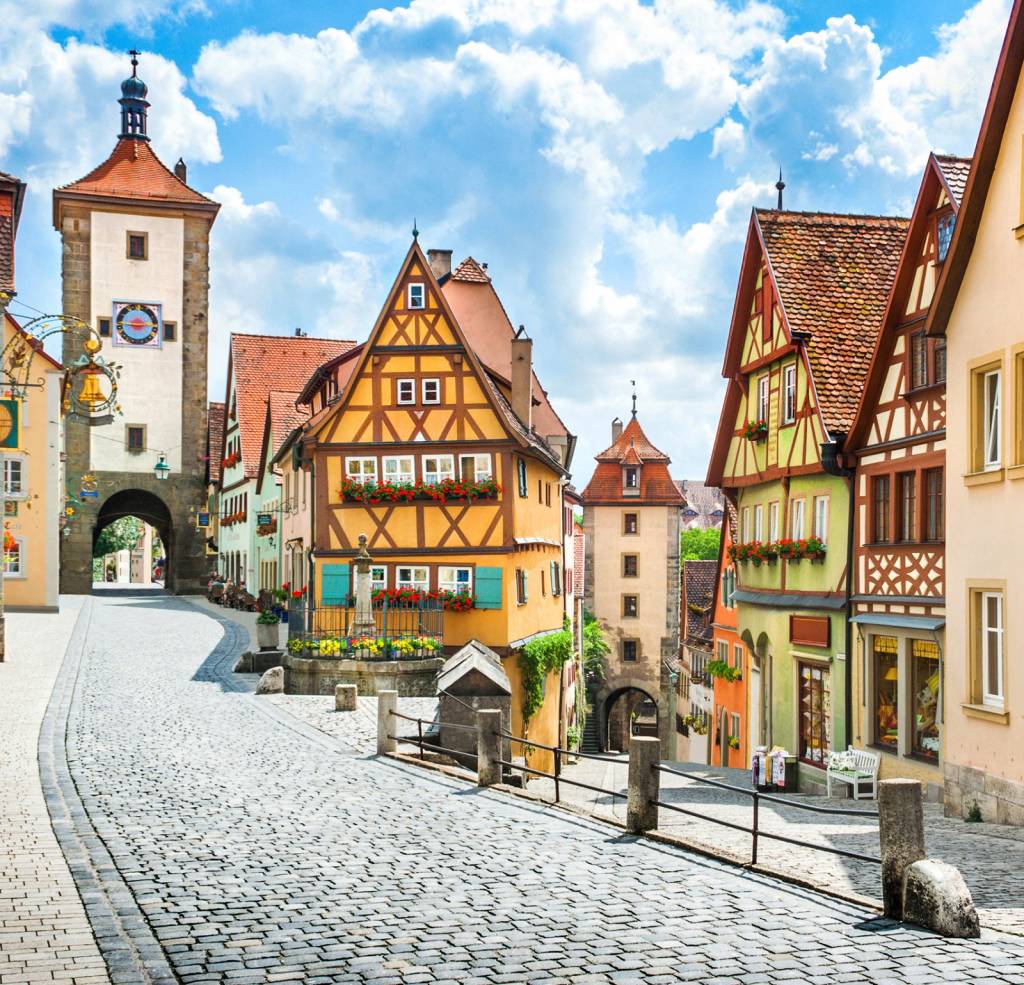 Beautiful postcard view of the famous historic town of Rothenburg ob der Tauber on a sunny day with blue sky and clouds in summer, Franconia, Bavaria, Germany