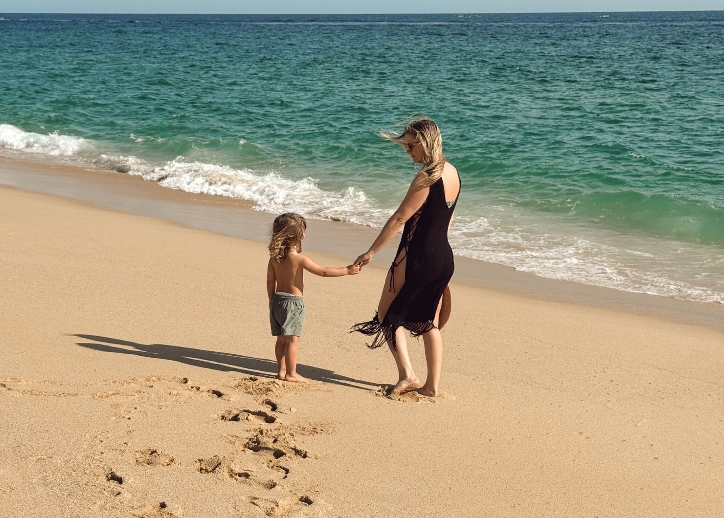 The Blonde Abroad and son on a beach