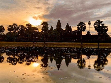 angkor wat as the run rises behind with the reflection glisening on the lake