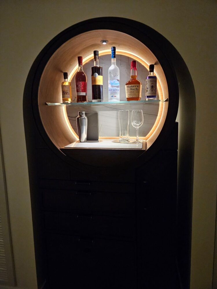 Mini bar is walnut with large mirror and round light behind the bottles so they really stand out.