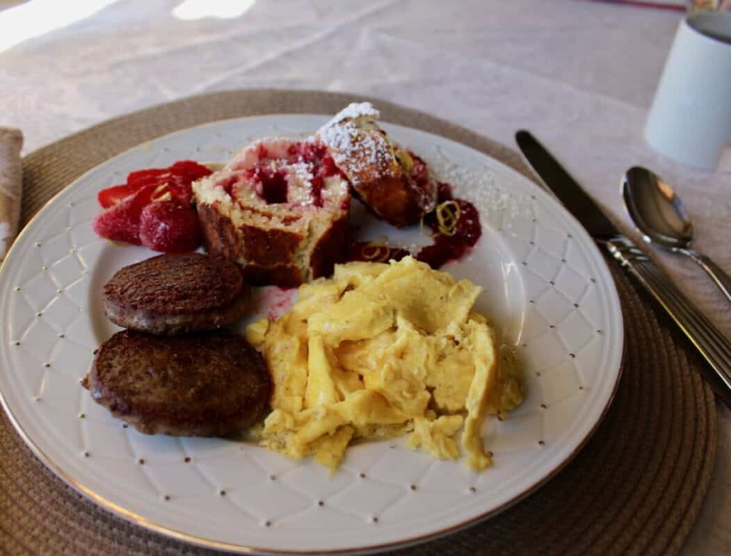 homemade breakfast of eggs, sausage, and pastry